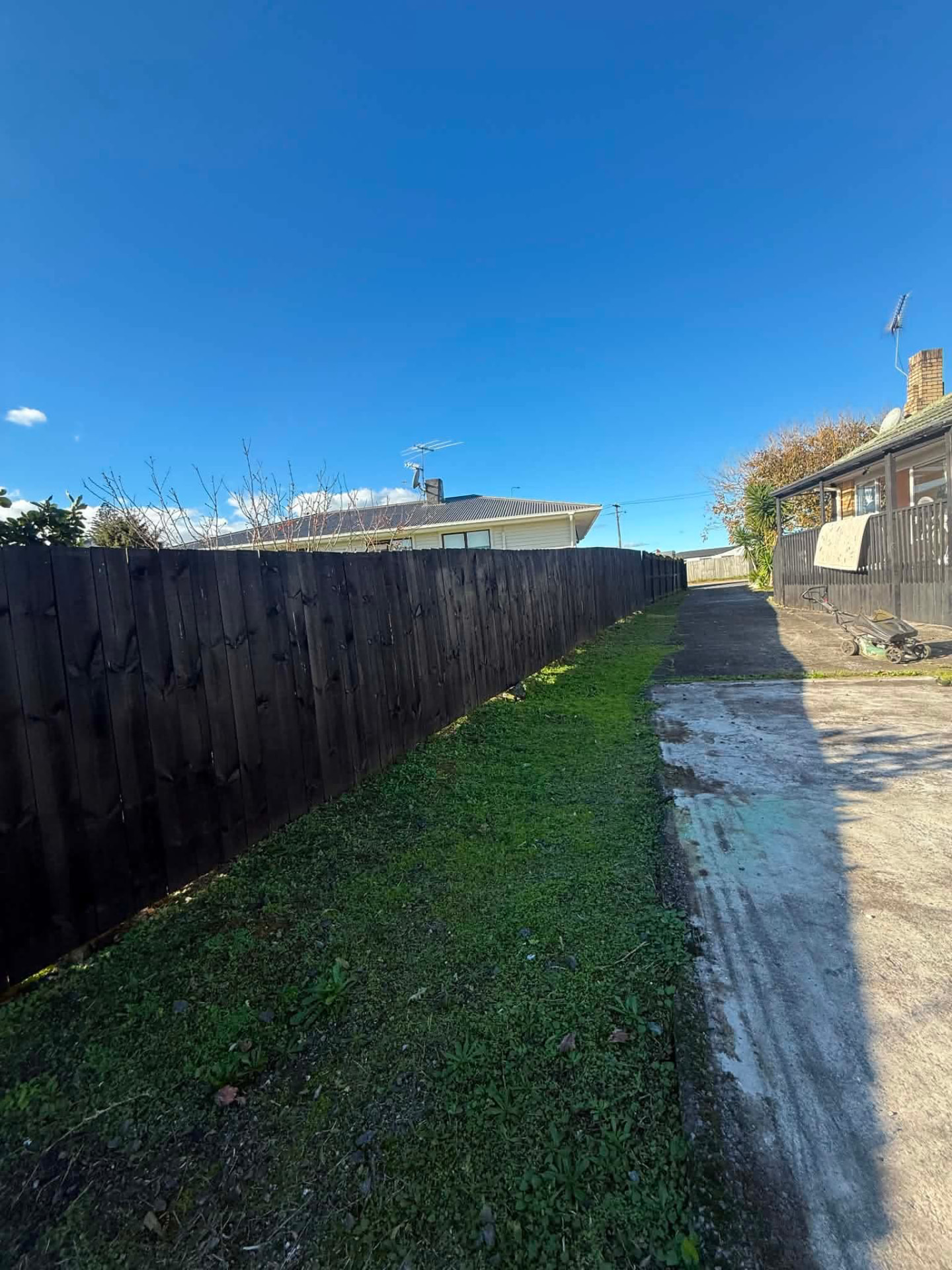 Driveway strip trimmed along a black fence by Tauwhare Lawn Care Services