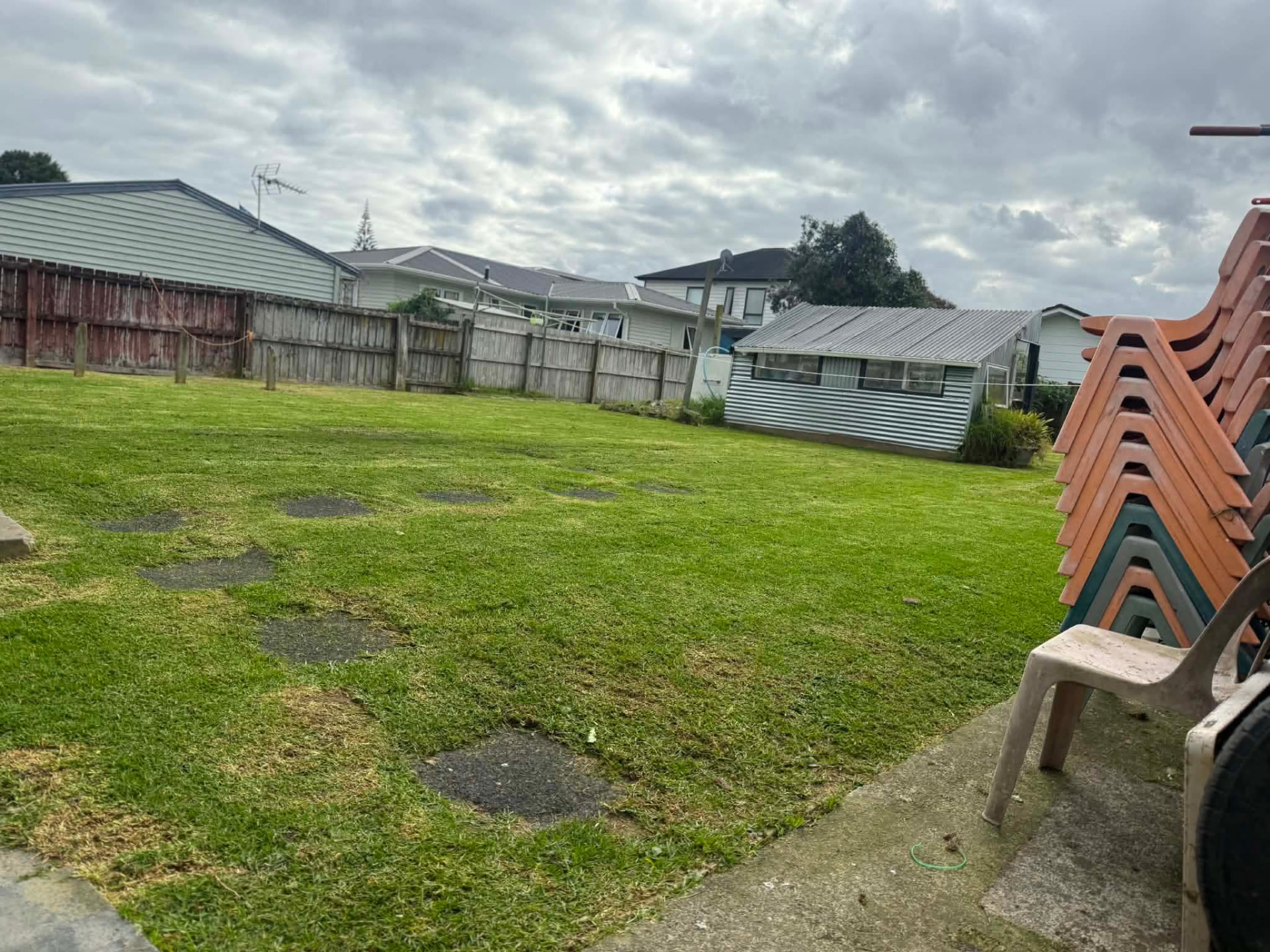 Wide back lawn mowed neatly beside a garden shed by Tauwhare Lawn Care Services